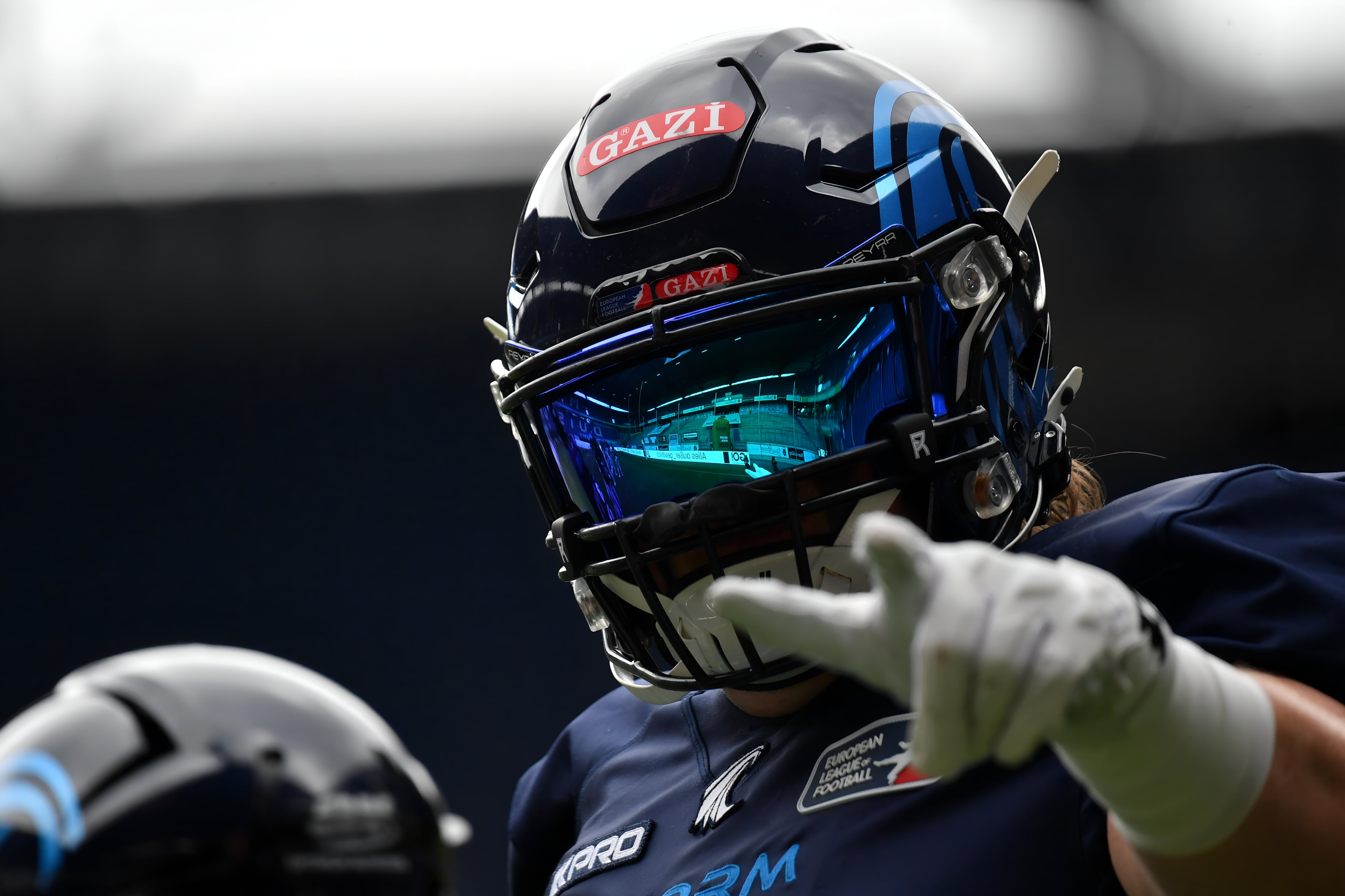 Person wearing a helmet with 'Gazi' branding in a dark setting